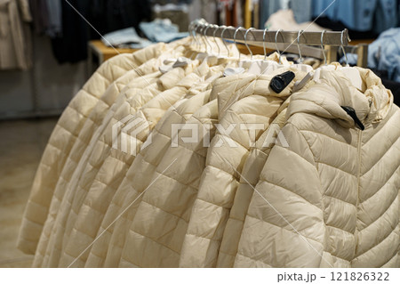 Cozy beige jackets displayed in a retail store for winter fashion season Cozy beige jackets displayed in a retail store for winter fashion season 121826322