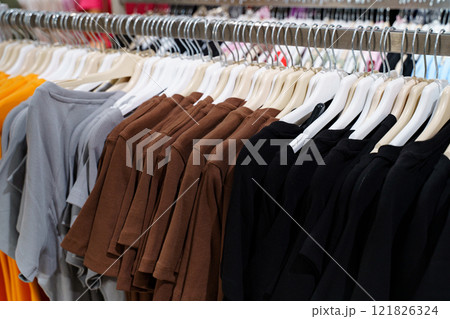 Diverse collection of casual t-shirts displayed in a vibrant retail setting Diverse collection of casual t-shirts displayed in a vibrant retail setting 121826324