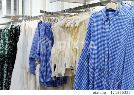 Unique clothing display showcases stylish summer attire in a bright store Unique clothing display showcases stylish summer attire in a bright store 121826325