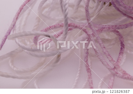 strand of white fade to purple yarn on white background mess strand of white fade to purple yarn on white background mess 121826387