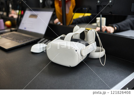 Virtual reality headset and laptop on modern office desk, technology workspace, innovative tech concept 121826408