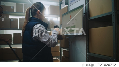 Female Parcel Processing Specialist Checks Package Delivery Information at Postal Terminal Female Parcel Processing Specialist Checks Package Delivery Information at Postal Terminal 121826712