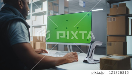 African American Warehouse Associate Scans Code on Parcel. PC Screen with Green Screen Mock Up 121826816