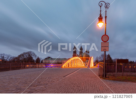 Illuminated bridge to the cathedral on Tumski Island at sunrise, Poznan, Poland 121827005
