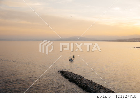 View of two sailboats in the north bay of Ceuta, in front of the chorrillo beach, at sunset. 121827719