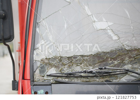 Cracked Windshield of a Red Vehicle Depicting Damage and Repair Needs 121827753