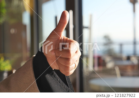 Hand Gesture A Thumbs Up Sign in a Welcoming Indoor Setting Here 121827922