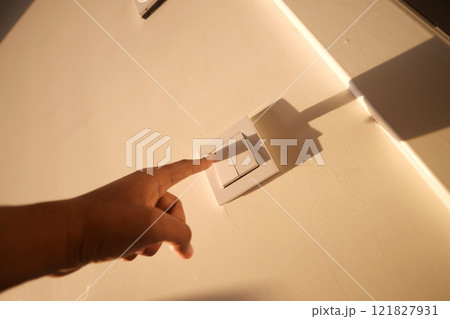 A finger turning on lighting switch . A finger turning on lighting switch . 121827931