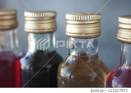 Vibrantly Colorful Bottles of Syrups Featuring Elegant Golden Caps 121827971