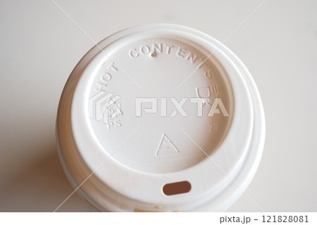 Coffee cup lid with caution hot and recycling symbols for sustainability and safety in urban Coffee cup lid with caution hot and recycling symbols for sustainability and safety in urban 121828081