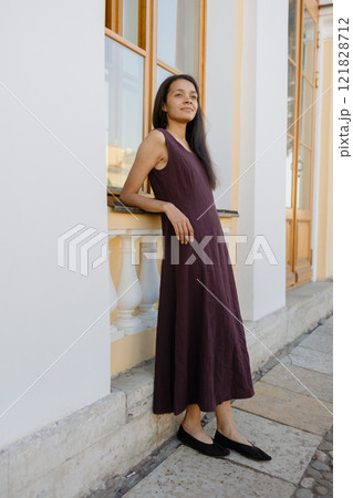 young African American woman in brown dress poses in park. happy female model at sunset in summer 121828712