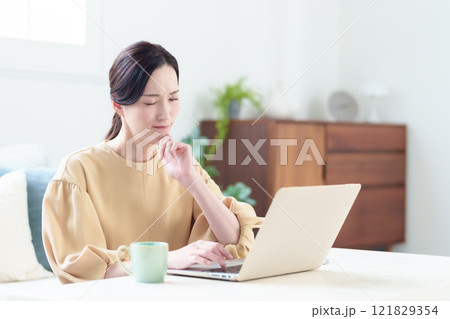 困った表情でパソコンを使う女性 121829354