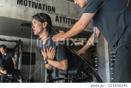 スポーツジムでパーソナルトレーニングを受ける若いアジア人男性 121830245