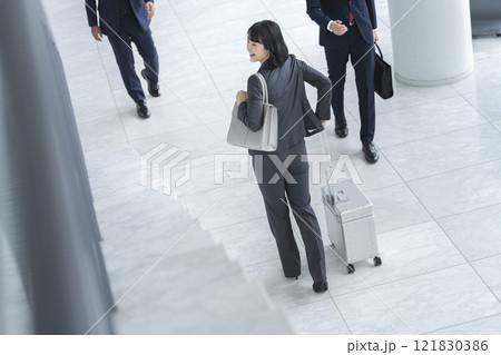 キャリーバッグを引いて歩くミドルのビジネスウーマン 121830386
