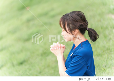 祈るように日本代表を応援するサッカーファン・サポーターの日本人女性 121830436