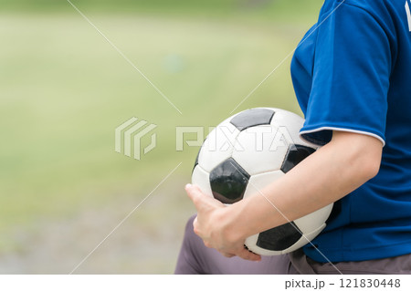 サッカーボールを持ちながら笑顔でサッカー観戦するサッカーファン・サポーター 121830448