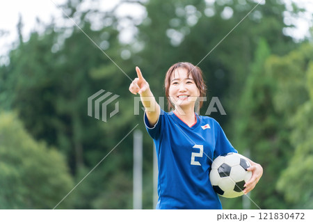 サッカーボールを持ちながら笑顔でサッカーするファン・サポーターの日本人女性 サッカーボールを持ちながら笑顔でサッカーするファン・サポーターの日本人女性 121830472