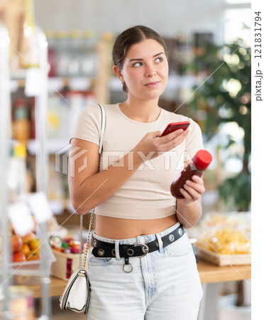 Young woman scanning qr code for ketchup Young woman scanning qr code for ketchup 121831794
