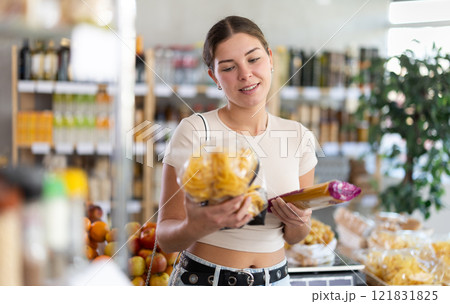 Young woman choosing pasta in store 121831825
