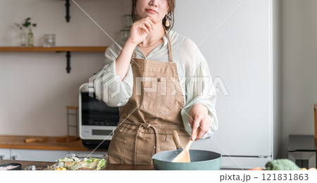 キッチンで調理中に考える女性(困る・献立・レシピ・メニュー) キッチンで調理中に考える女性(困る・献立・レシピ・メニュー) 121831863