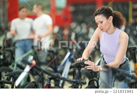 Adult woman choosing bike in store 121831991
