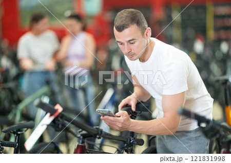 Young man choosing bike in store 121831998