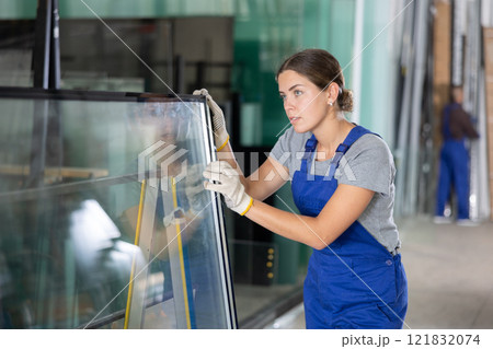 Female worker inspecting insulated glass units in production workshop Female worker inspecting insulated glass units in production workshop 121832074