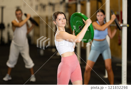 Young woman training with weight plate 121832298