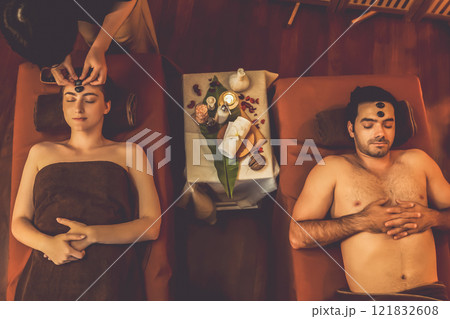 Caucasian couple enjoying relaxing anti-stress head massage with stone.Quiescent Caucasian couple enjoying relaxing anti-stress head massage with stone.Quiescent 121832608