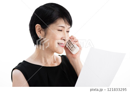 お客様と電話でにこやかに話す中年女性 121833295