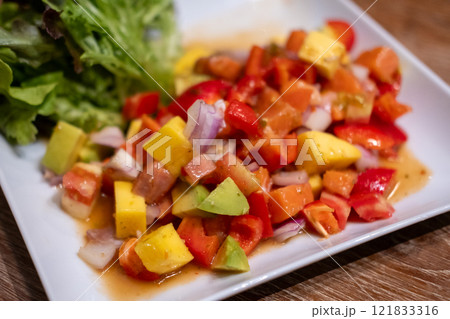Spicy Salmon sashimi with mango salad served on plate Spicy Salmon sashimi with mango salad served on plate 121833316