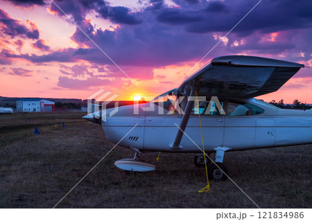 Small private aircrafts parked at the airfield at picturesque sunset 121834986