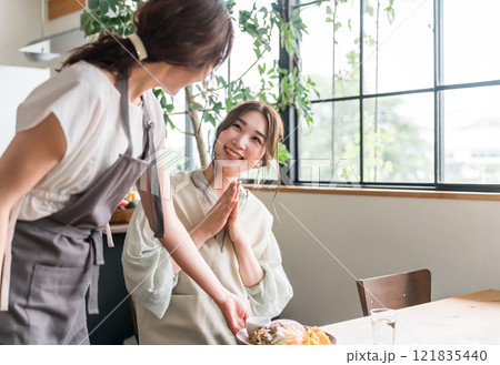 カフェでワンプレートランチを提供する店員と女性客 カフェでワンプレートランチを提供する店員と女性客 121835440
