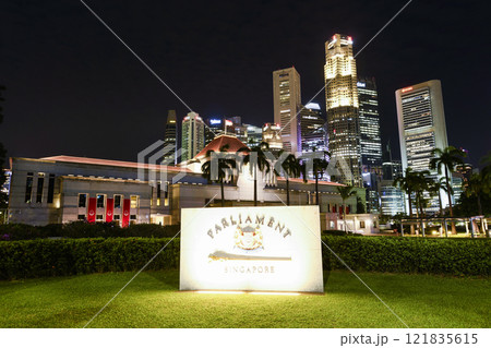 Night view of the Singapore Parliament House, which is a public building and a cultural landmark on the bank of the Singapore River, with a background of Financial District skyscrapers. 121835615