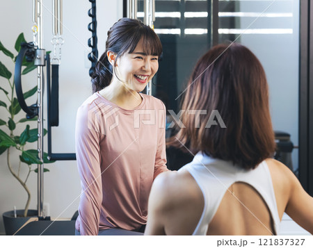 ジムでインストラクターにカウンセリングを受ける女性 121837327