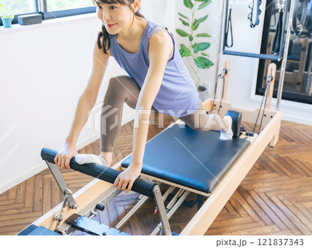 マシンピラティスのトレーニングをする女性 121837343