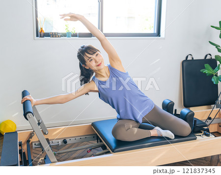 マシンピラティスのトレーニングをする女性 121837345