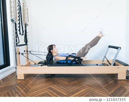 マシンピラティスのトレーニングをする女性 121837355
