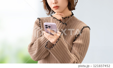 スマホを見て考える女性・ビジネスウーマン 121837452