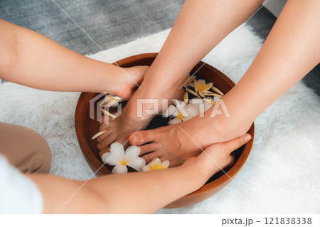 Woman indulges in blissful foot massage at luxurious spa salon. Quiescent Woman indulges in blissful foot massage at luxurious spa salon. Quiescent 121838338