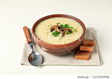 A bowl of cream of mushroom soup with parsley and croutons 121838498