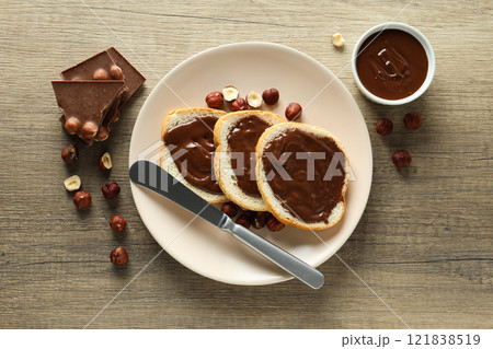 Bread with chocolate paste in a bowl on a wooden background 121838519