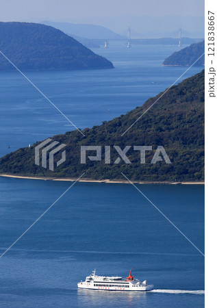 瀬戸内海、備讃瀬戸の女木島沖を行く小豆島フェリー、遠景は瀬戸大橋 121838667