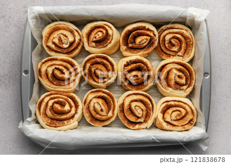 Delicious cinnamon rolls prepared for baking in a rectangular pan Delicious cinnamon rolls prepared for baking in a rectangular pan 121838678