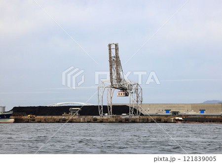 LargeLarge crane works on large coal stockpile at Osaka port. crane works on large coal stockpile at Osaka port. 121839005
