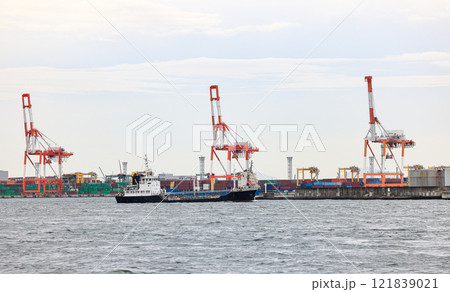Container port at Osaka Japan, container crane at Industrial port for cargo container ship. Cargo transportation and activity at modern shipping container terminal. Container port at Osaka Japan, container crane at Industrial port for cargo container ship. Cargo transportation and activity at modern shipping container terminal. 121839021