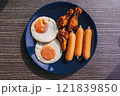 Breakfast set of Fried eggs, sausage and fried chicken wing. 121839850