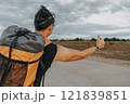 Man tourist backpacker hitchhike for pickup on the local country road. 121839851