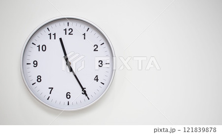 Minimalist White Clock with Silver Frame Striking 23.25/11.25 on White Background. Perfect for Time Management and Corporate Campaigns 121839878
