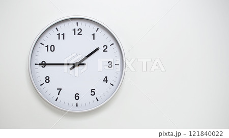 Minimalist White Clock with Silver Frame Striking 13.45/01.45 on White Background. Perfect for Time Management and Corporate Campaigns 121840022